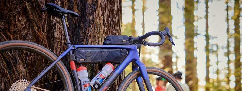 Gravel pyörä joka on varustettu runkolaukuilla ja juomapulloilla