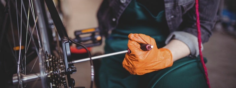 Kuvassa pyörän taka-akselia käännetään auki t-kahvalla